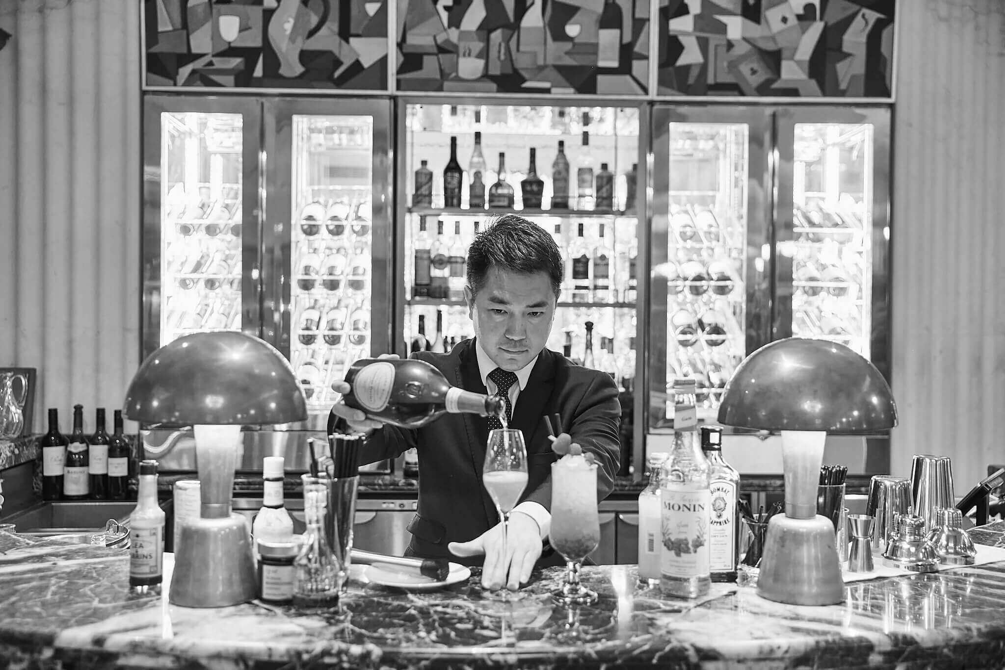 A man pouring champagne at a bar