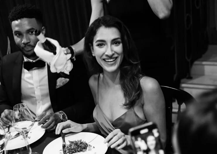 A woman wearing a dress ready to eat her food, smiling