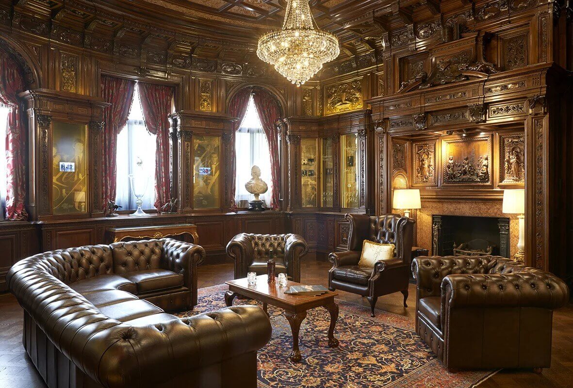 A large dark wood room with leather furniture