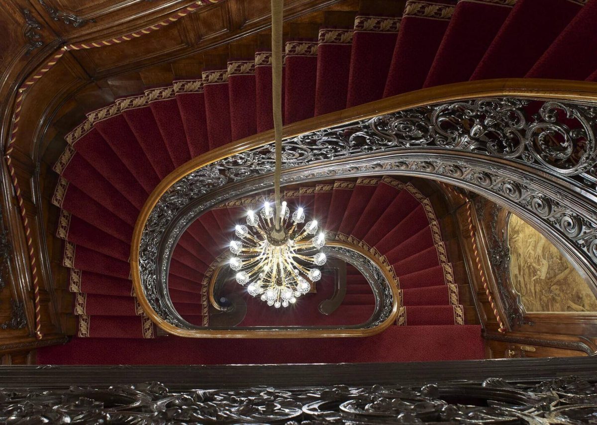 A fabulous, winding staircase with a chandelier in the centre