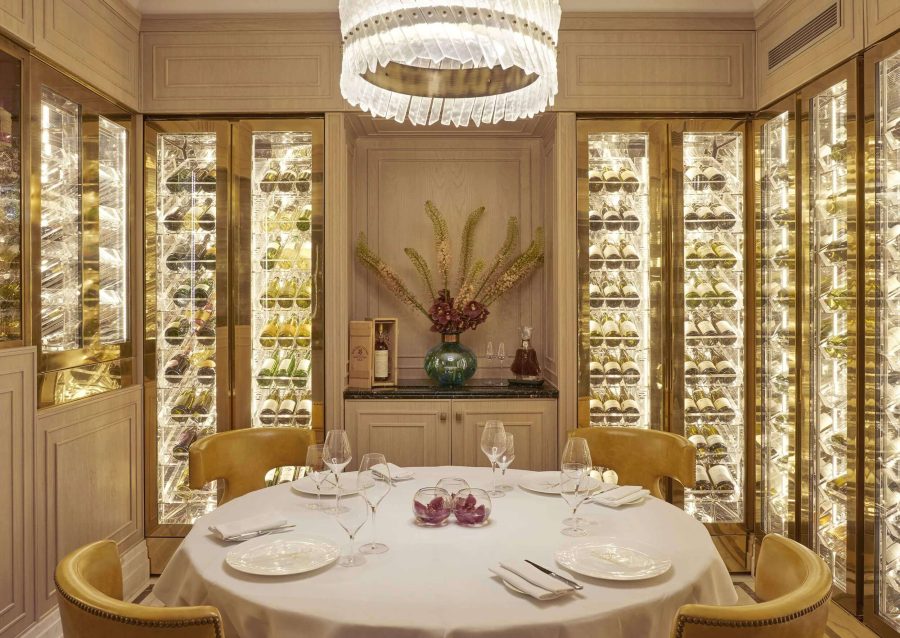 A table set for four surrounded by fridges containing white wine