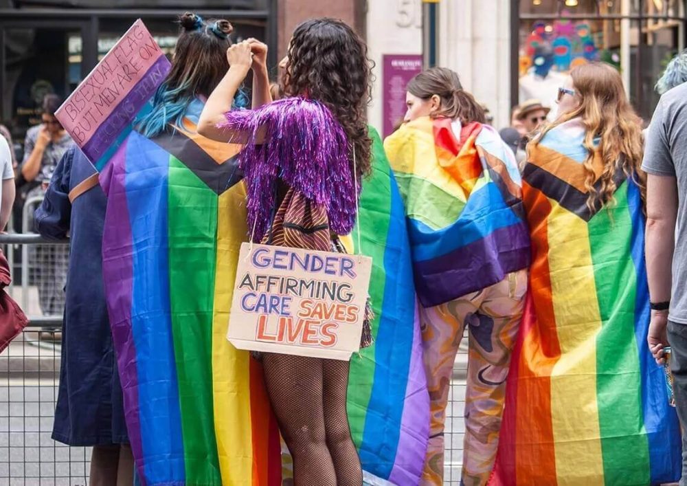 People supporting London Pride with pride flags and signs.
