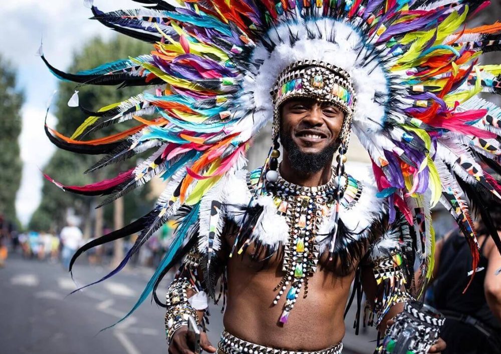 A man wearing a colored feathered outfit and headpiece.