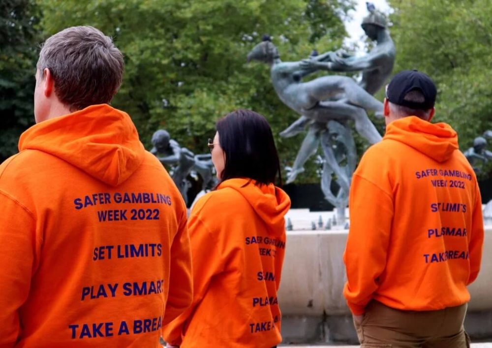 Three people wearing hoodies to promote safer gambling