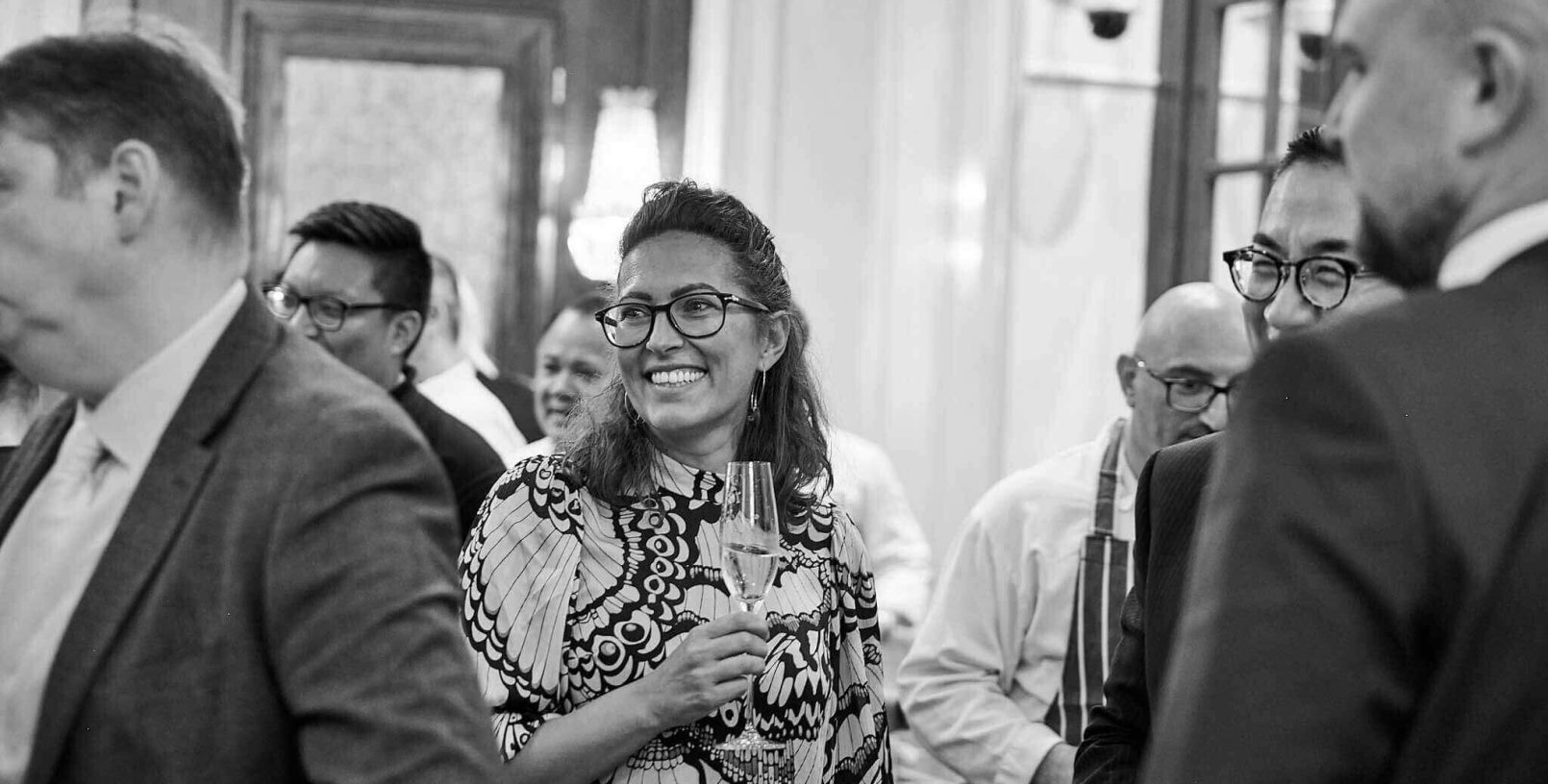 A woman smiling with a glass of champagne