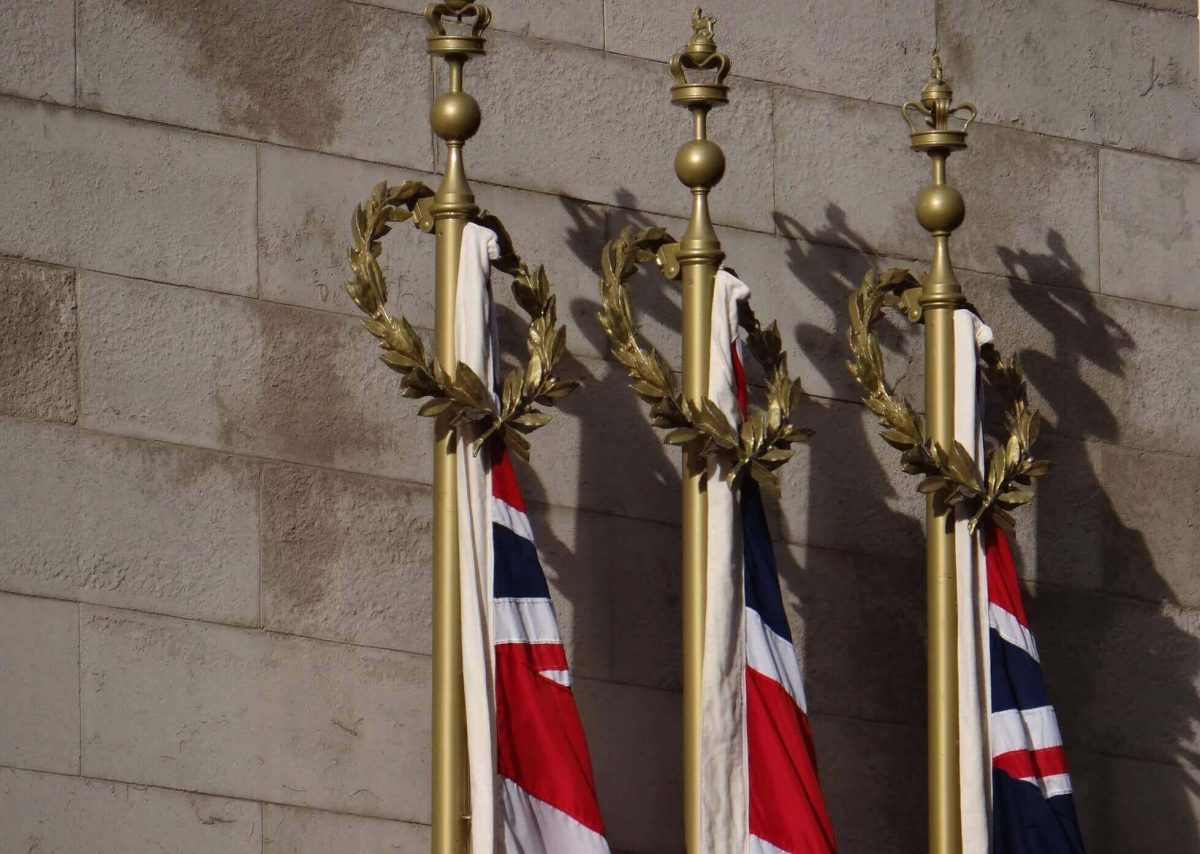 Image of 3 royal statues with Great British flag attached.