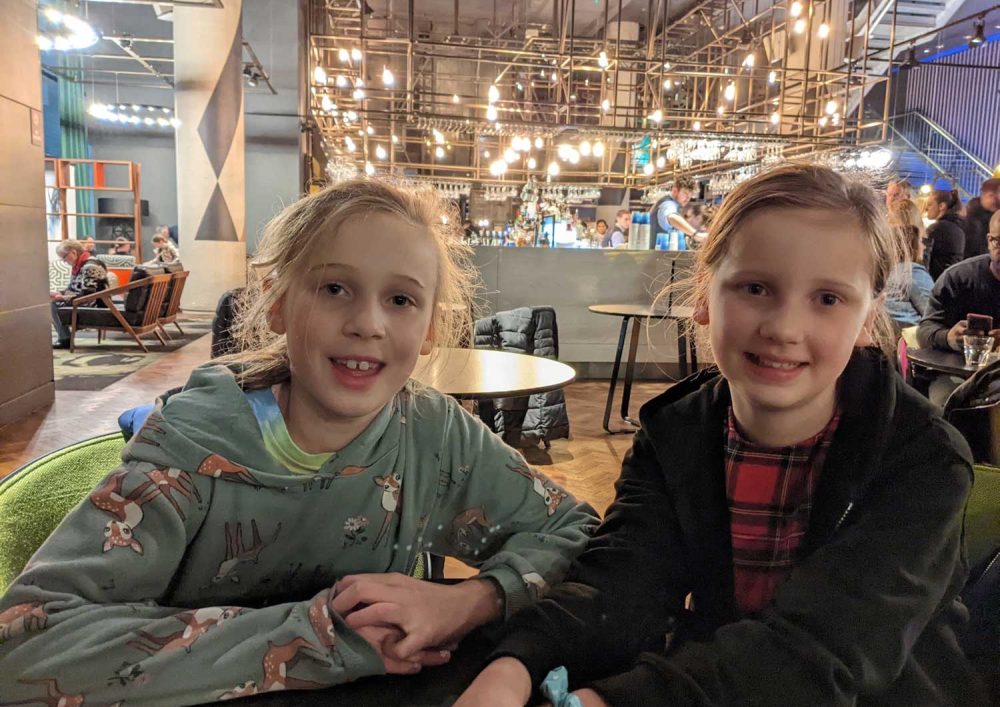 Kids at a table in a restaurant, smiling